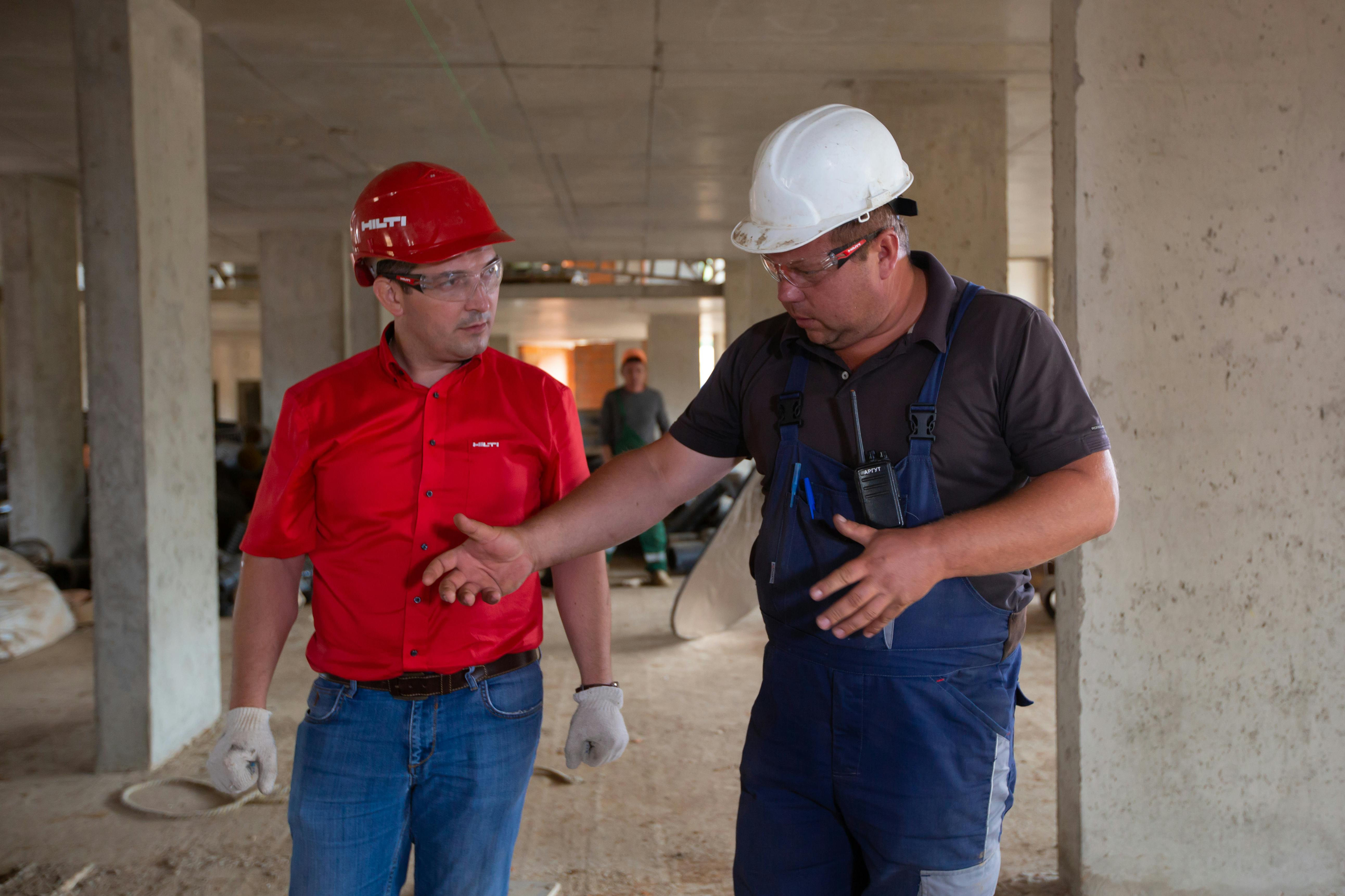 An image of two construction workers walking and talking