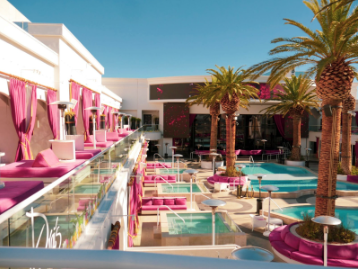 An image of a hotel pool with chair and umbrellas around