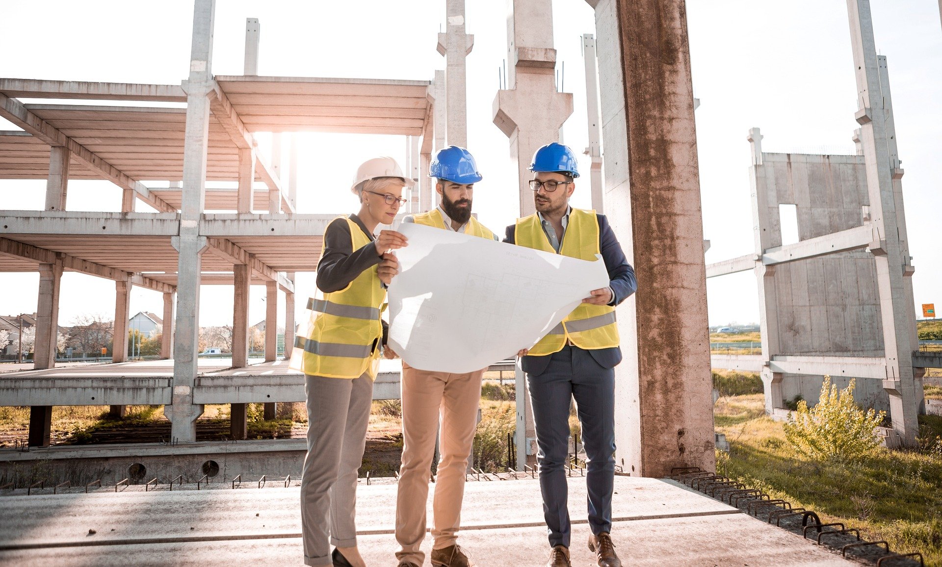 architects talking to construction workers with plans