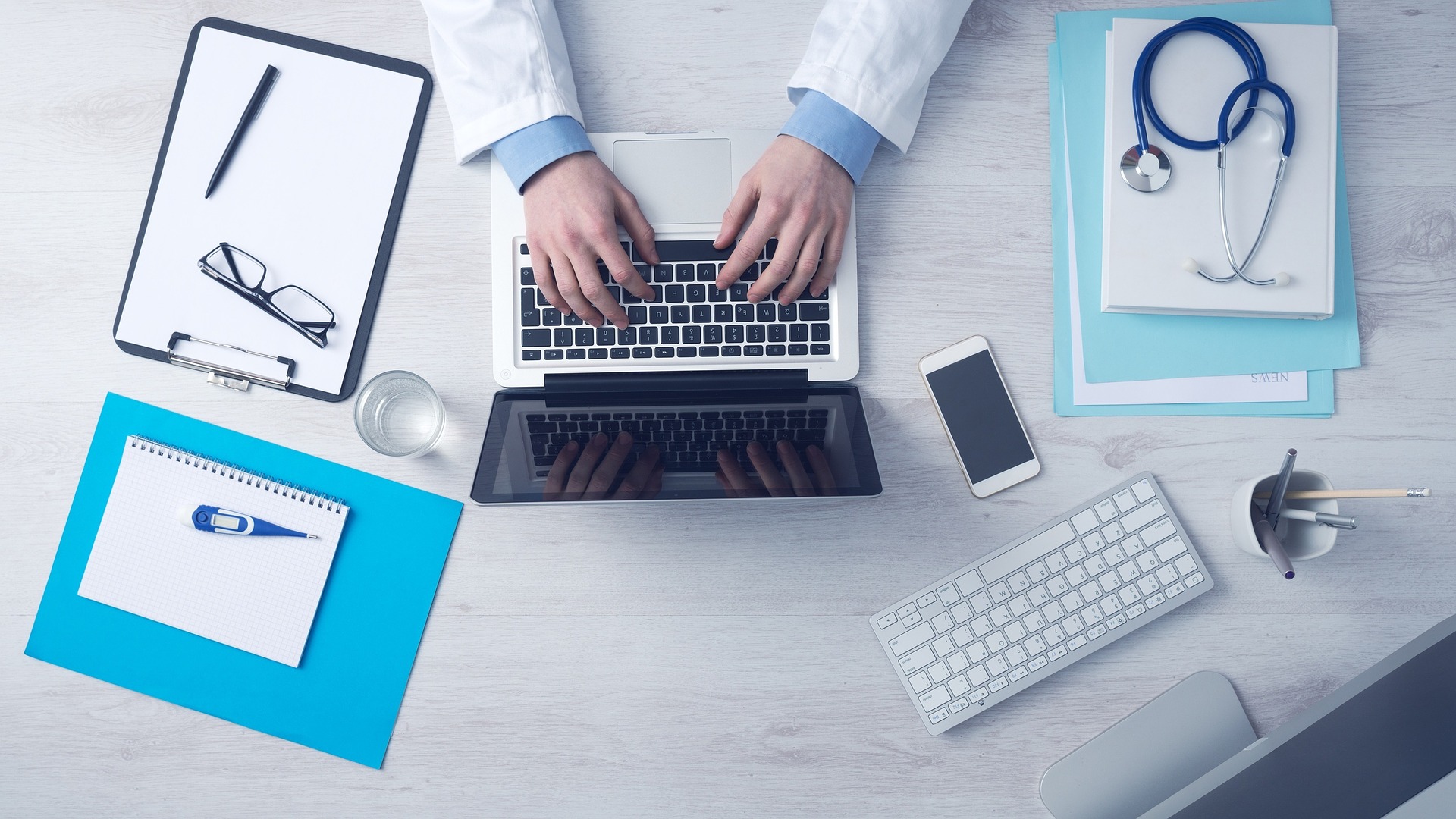 doctor on computer with physician tools on desk