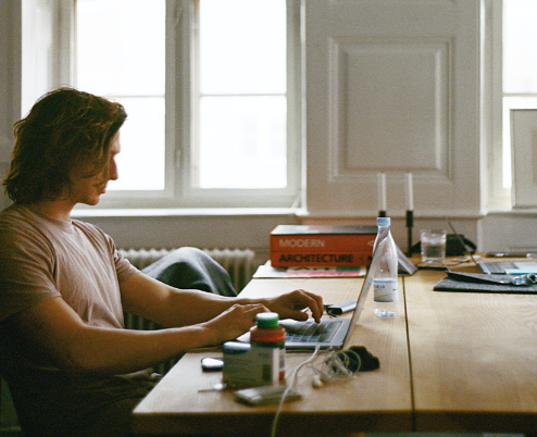 a person sitting at a table in front of a window