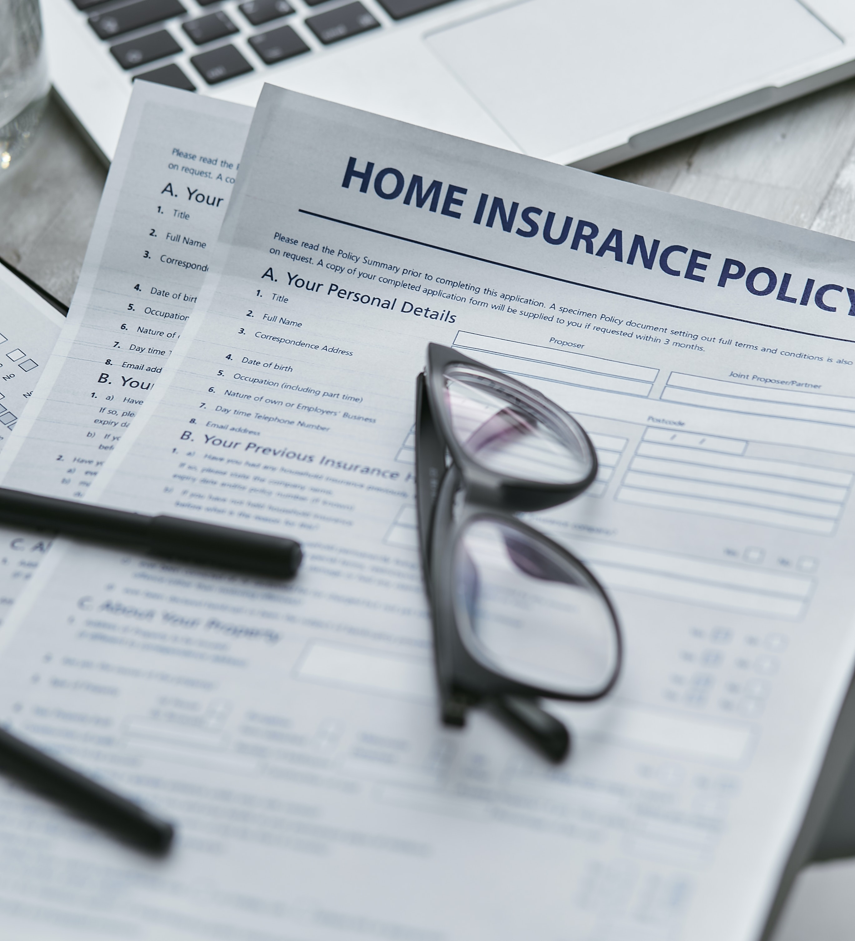 A homeowners insurance policy with reading glasses on top of it