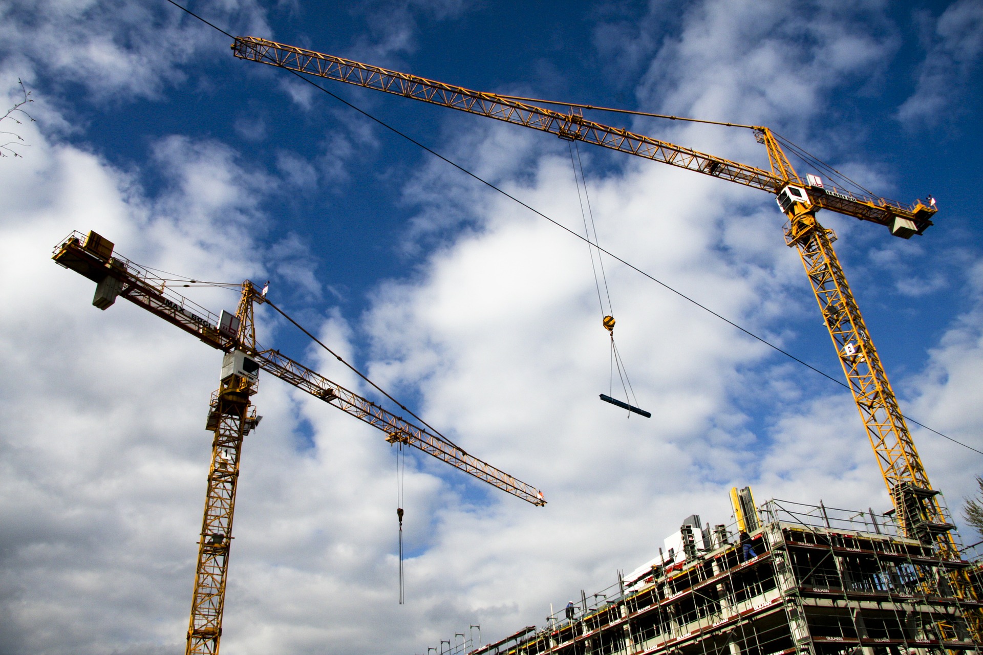 2 cranes sitting at a job site