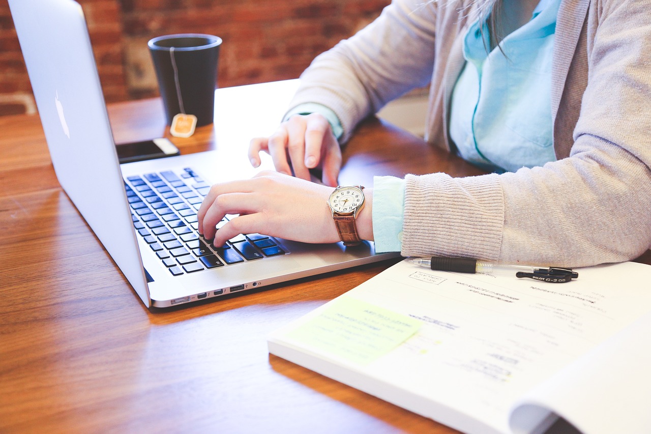 And image of a person using a laptop while drinking tea