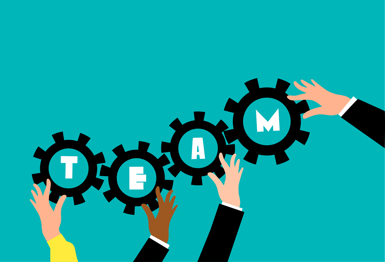 An image of the word "team" with peopl ehelping to place the letters