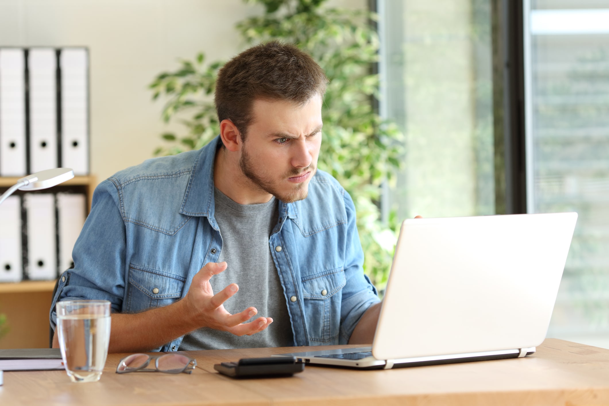 a man sitting at a table using a laptop computer