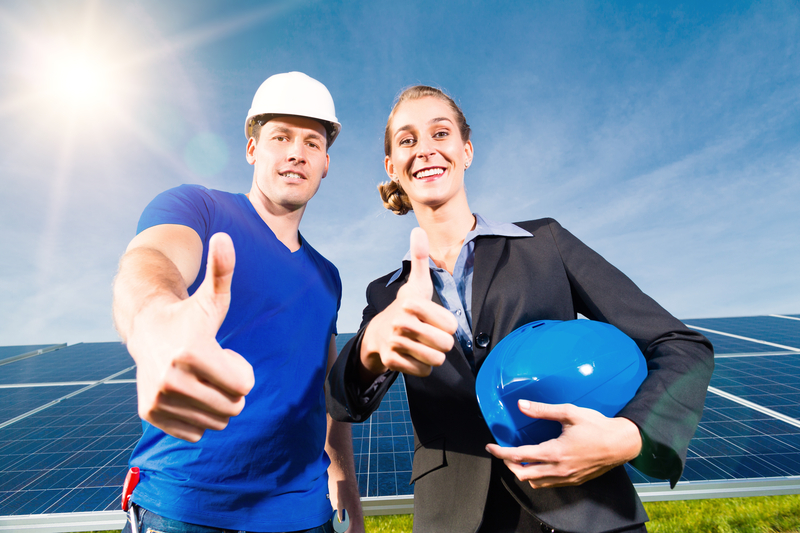 workers standing in front of solar panels